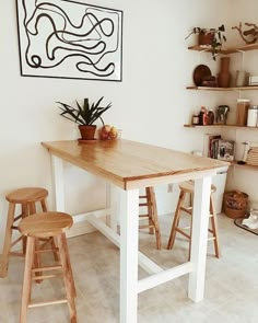 a kitchen table with two stools next to it