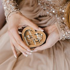 a woman holding a wooden heart in her hands