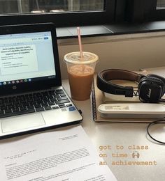 an open laptop computer sitting on top of a desk next to a cup of coffee