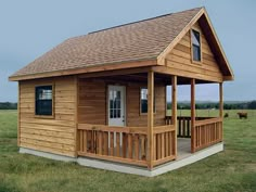 a small wooden cabin sitting on top of a lush green field next to a cow