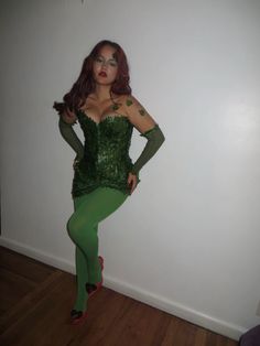 a woman dressed in green is posing for the camera