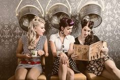 three women are sitting on chairs and reading