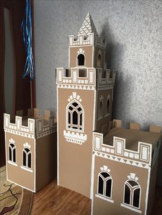 two cardboard castles sitting on top of a wooden floor