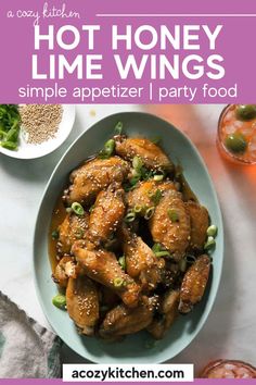 chicken wings with sesame seeds and green onions in a white bowl on a marble counter top