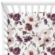 a white crib with purple and pink flowers on it