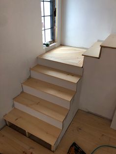 a set of wooden stairs leading up to a window