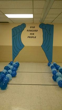 some blue balloons are on the floor in front of a sign that says god receid his people