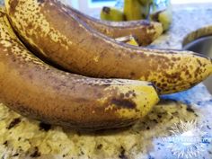 three ripe bananas sitting on top of a counter