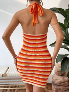 a woman in a short dress with an orange and white striped halter