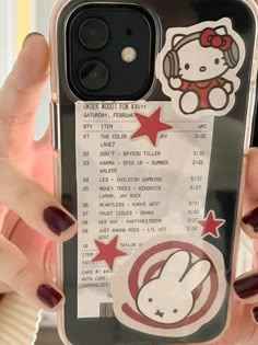 a person holding up a cell phone case with a hello kitty sticker on it