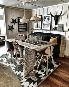 a dining room table with chairs and pictures on the wall above it, along with other decor items