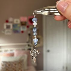 a person holding onto a metal object with beads and charms on it's end