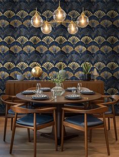 a dining room table with blue chairs and an art deco wallpaper