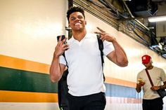 a man in white shirt and black suspenders holding up his hand