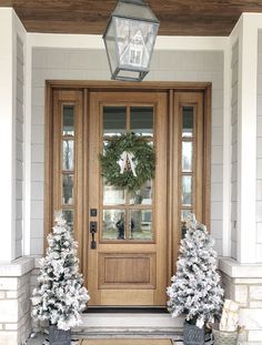 the front door is decorated for christmas with wreaths