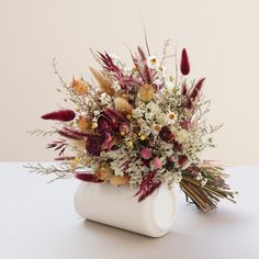 a white vase filled with lots of flowers