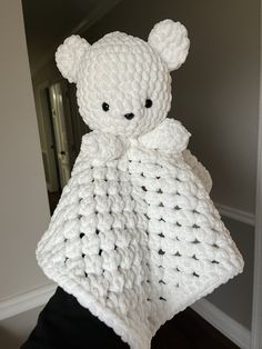 a crocheted teddy bear wrapped in a blanket