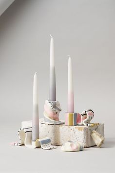 a group of different colored candles sitting on top of each other