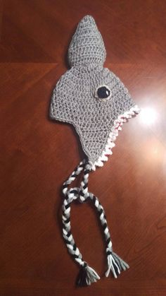 a crocheted gray hat with black eyes and teeth