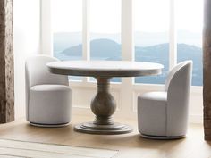 a white table and chairs sitting in front of a window with mountains out the window