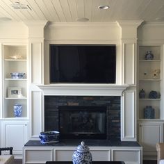 a living room filled with furniture and a flat screen tv mounted above a fire place