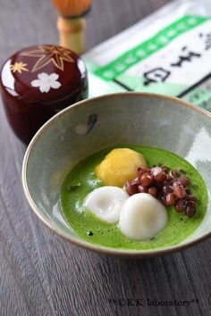 a bowl filled with green soup and two boiled eggs