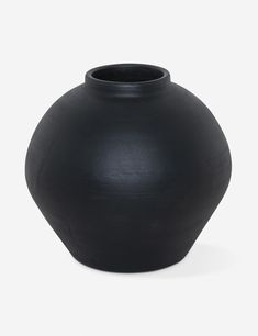 a black vase sitting on top of a white table