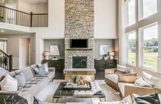 a living room filled with furniture and a flat screen tv mounted on the wall above a fireplace