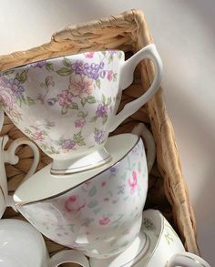 a basket full of tea cups and saucers