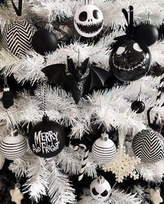 a white christmas tree decorated with black and white ornaments, jack - o - lantern ornament