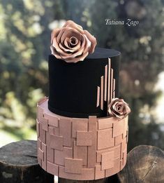 a three tiered cake decorated with flowers on top of wooden logs in front of trees