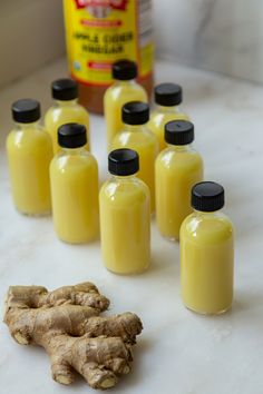 Glass bottles of ginger shots surrounded by sliced lemons and a bottle of apple cider vinegar, capturing the essence of wellness. Diy Ginger Shots, Ginger Shots Recipe, Ginger Shot Benefits, Vegan Breakfast Casserole, Low Calorie Cocktails, Easy Summer Cocktails, Vegan Breakfast Easy