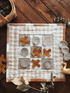 a table topped with wooden crosses and plates on top of a checkered cloth covered placemat