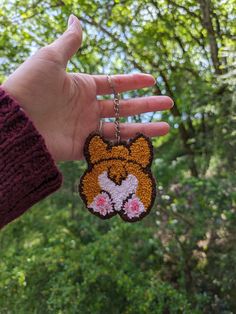 a hand holding a key chain with a tiger face on it