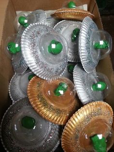 there are many plates in the box that have green apples on them and silver foil