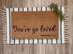 a door mat with the words you're so loved on it sitting on a wooden floor