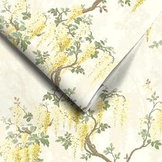 a wallpaper with yellow flowers and green leaves on white paper next to a knife