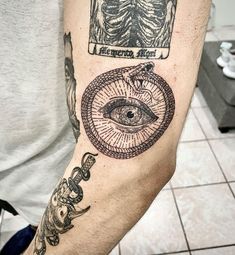 a man's arm with an all seeing tattoo on it