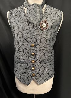 Steampunk Vest Brocade Waistcoat Gothic Renaissance This is a stunning black / grey  waist coat with a vintage design  It is fully lined and well made. It has pockets  and adjustable back. It comes with a matching cravat and a handcrafted  rustic metal frame tie pin. Chest measurement is 2 sizes M approx 38/40 L approx 42/44 Length front approx 24" Length back approx 23" Makes a stunning steampunk gentleman's outfit!  Thank you for looking Steampunk Formal Sleeveless Vest, Formal Steampunk Sleeveless Vest, Formal Sleeveless Steampunk Vest, Steampunk Sleeveless Vest With Buttons, Vintage Fitted Vest For Cosplay, Steampunk Fitted Vest With Buttons, Black Fitted Steampunk Vest, Steampunk Style Black Vest For Costumes, Steampunk Black Vest For Costume Party