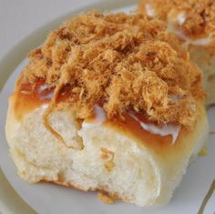 two pieces of food on a plate with crumbs and icing over them