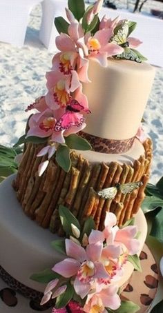 a three tiered cake with pink flowers on top