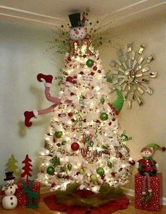 a white christmas tree decorated with ornaments and lights