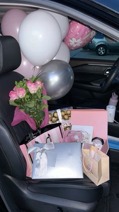 the back seat of a car filled with gifts and balloons, flowers, and other items