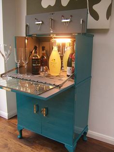 a blue cabinet with wine glasses and bottles in it