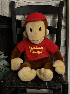 a stuffed monkey sitting on top of a wooden chair