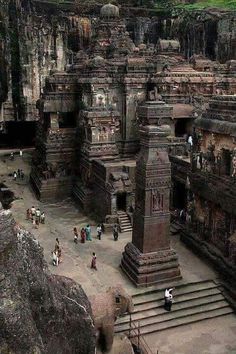 people are walking around in front of some very large stone structures at the cave temples