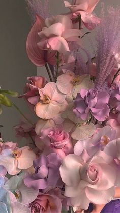 a vase filled with lots of pink and purple flowers