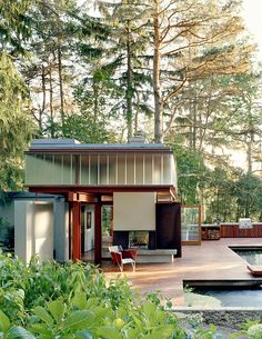 a small house in the middle of a wooded area with water and trees around it