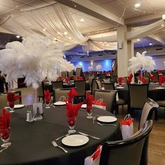 the tables are set with red napkins and white centerpieces for an elegant event