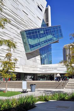 a large building with a curved glass window on it's side and stairs leading up to the entrance